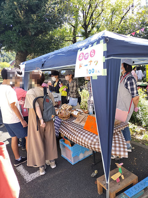 ドーナツ販売の屋台。数人の人が集まってドーナツを食べている
