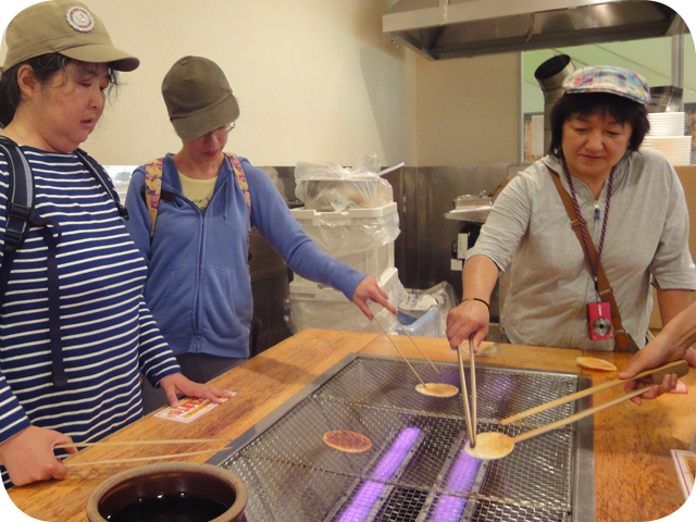 せんべいを焼く女性3人