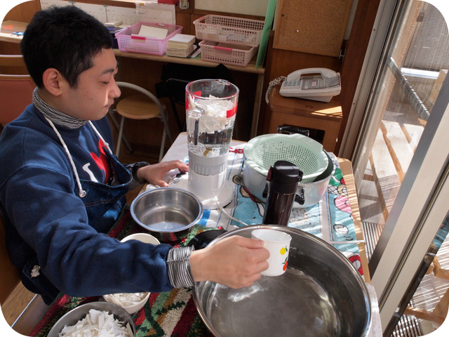 原料をミキサーにかける男性